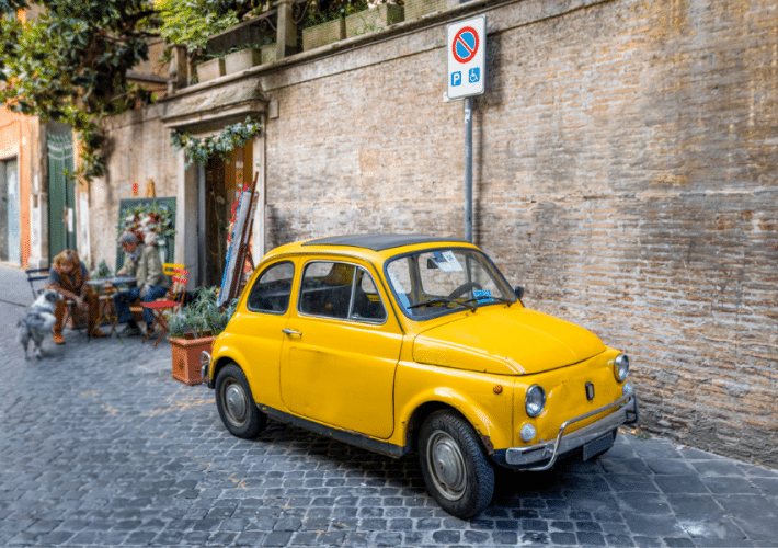 Yellow car on the street in Rome neighborhood Italy