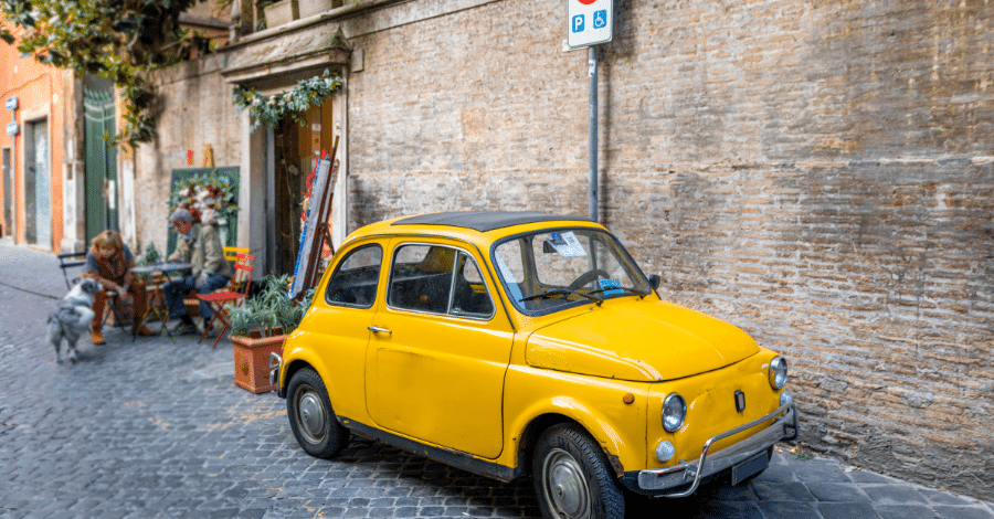 Yellow car on the street in Rome neighborhood Italy